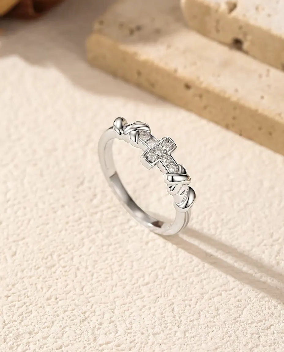 Moissanite Ring met Kruis in 925 Sterling Zilver - rechtop naast travertijnblokken, ruimer beeld