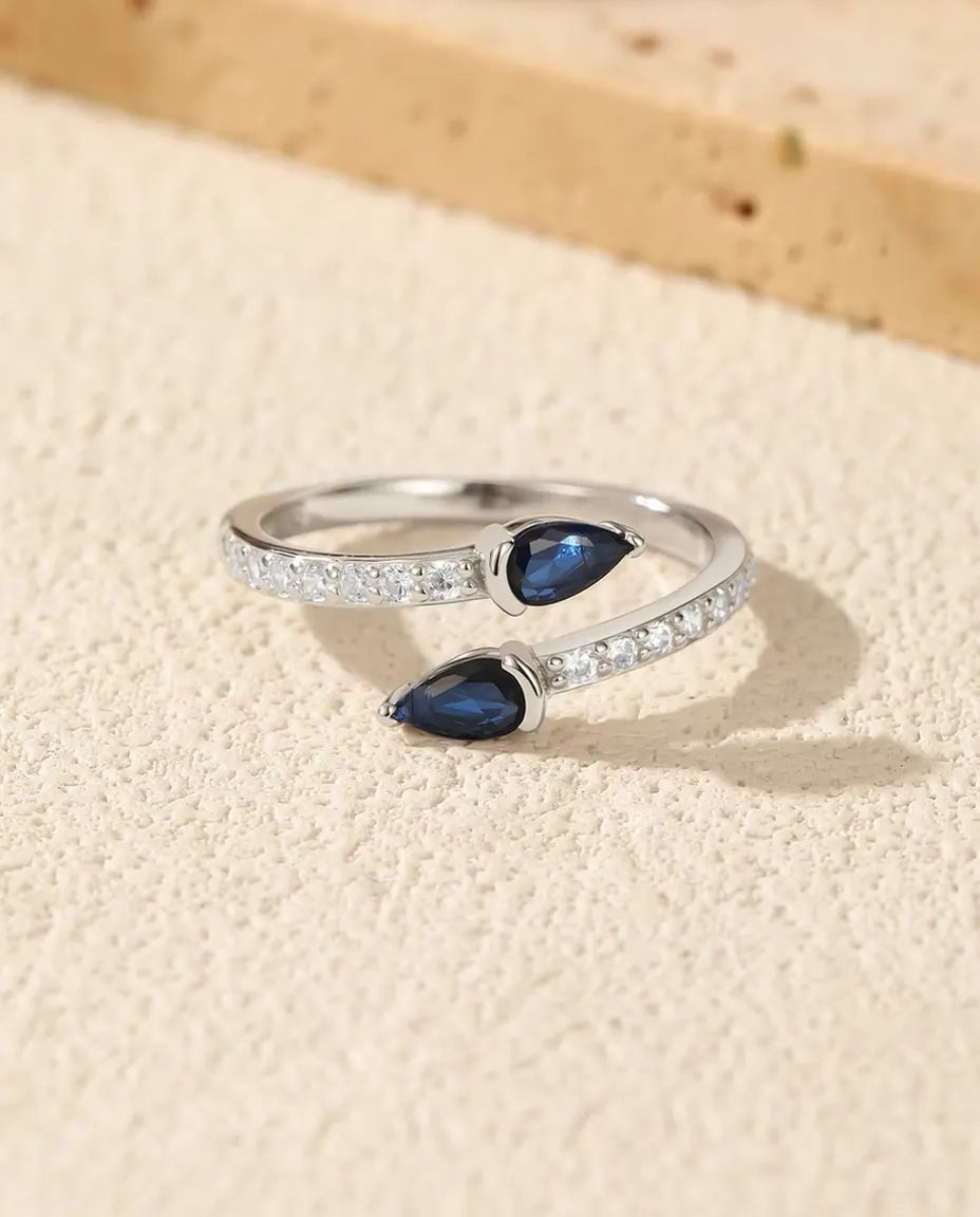Open Ring met Blauwe Druppels - twee stenen in peerslijpsel op open pavé band, 925 zilver, verstelbaar