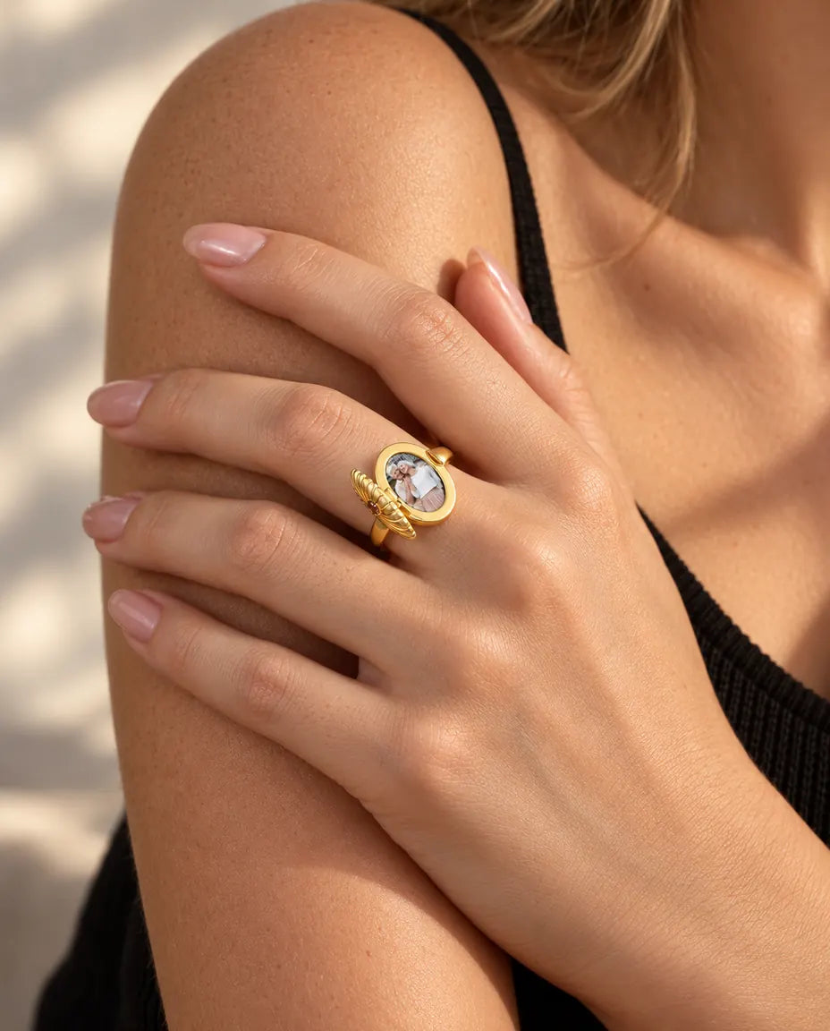 Vrouw draagt de ovale medaillonring opengeklapt, zodat de foto erin te zien is