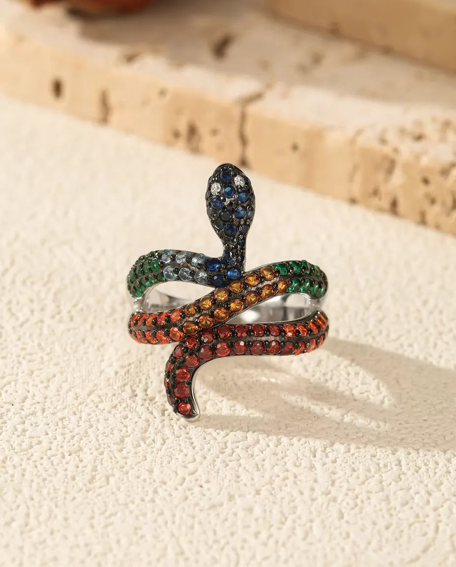 Slangenring in 925 Sterling Zilver met Regenboogsteentjes - rechtop op een licht gestructureerd oppervlak
