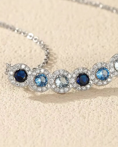 Staafketting Blauw Verloop - zes blauwe stenen met pavé halo, gebogen staaf 34 mm, 925 sterling zilver