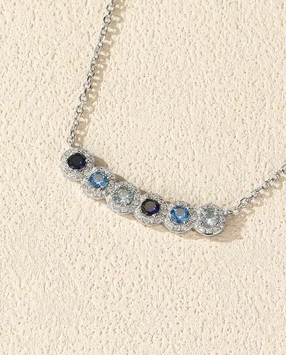 Staafketting Blauw Verloop - zes blauwe stenen met pavé halo, gebogen staaf 34 mm, 925 sterling zilver