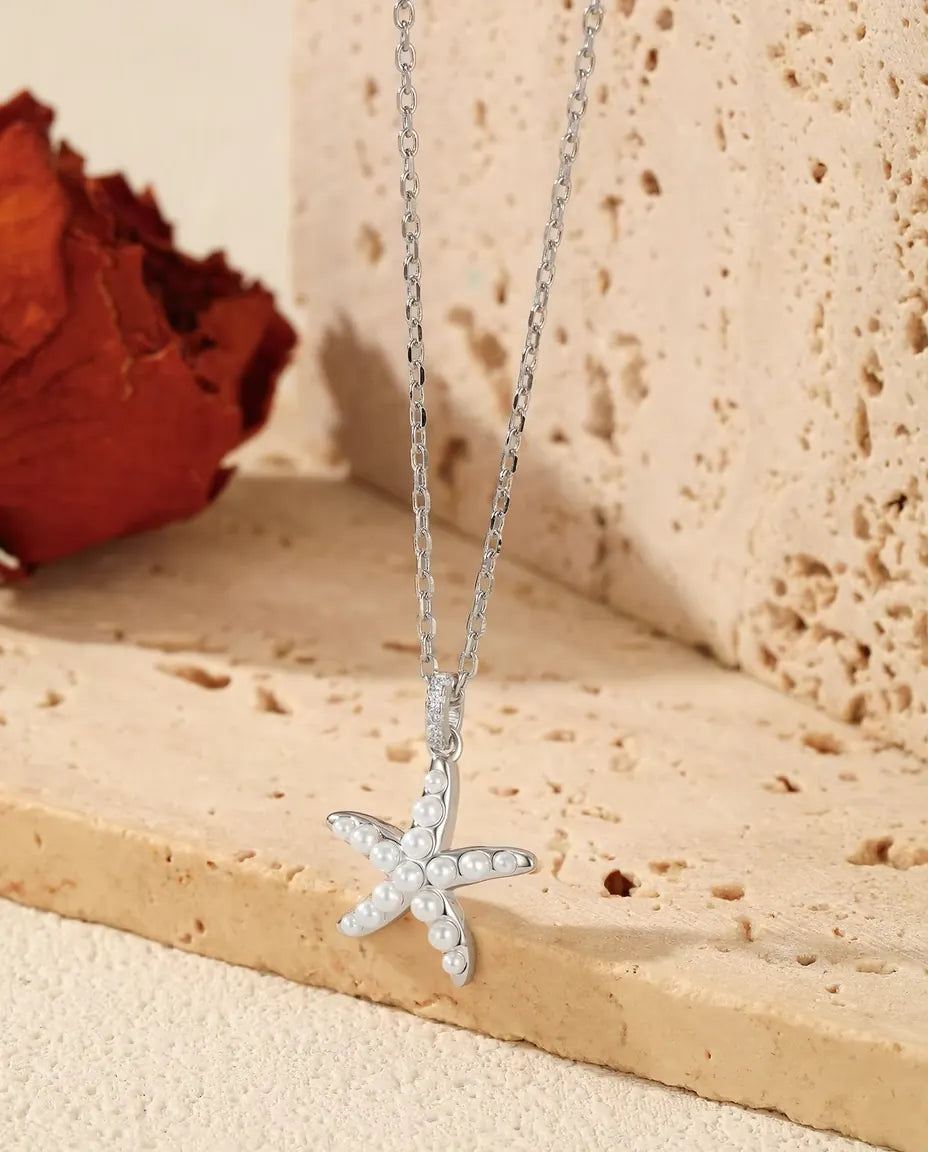 Zeester Ketting in 925 Sterling Zilver - hanger over de rand van een travertijnplaat